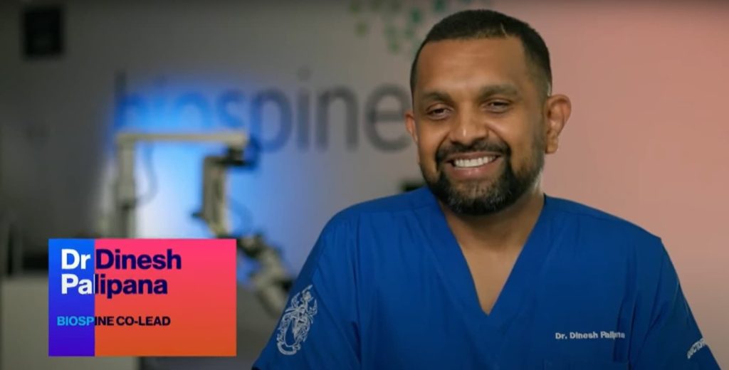 Smiling man wearing blue scrubs. Caption reads "Dr Dinesh Palipana BioSpine Co-Lead".